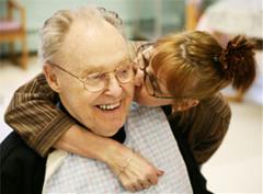 Woman kissing elder patient on the cheek